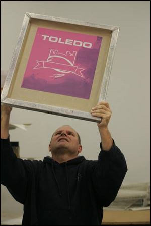 Ken Kaczorowski, silk-screen manager at Team Sports Inc., checks for pinholes in a just-completed screen.