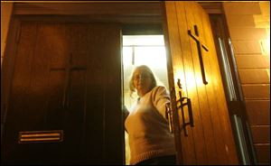 Kelli Lykins keeps watch over the North End Church of God, 2610 North Erie St., which is the frequent target of burglars.