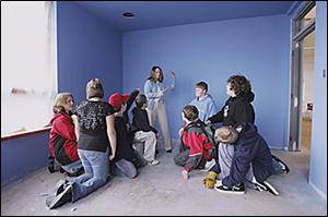 NBR wall04p Jan. 5, 2006 The Blade/Lori King Michelle Perkins, the Rossford Library young adult wall art program coordinator, shows her youngsters from Rossford Jr. High the wall they use as a canvas.