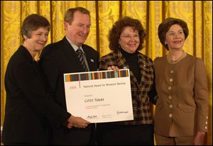 From left, Mary Chute of the Institute of Museum and Library Services, Dr. Michael Walsh
of COSI Toledo, and Birmingham Elementary teacher Pauline LoCascio accept the National
Award for Museum Service from First Lady Laura Bush during a White House ceremony.
