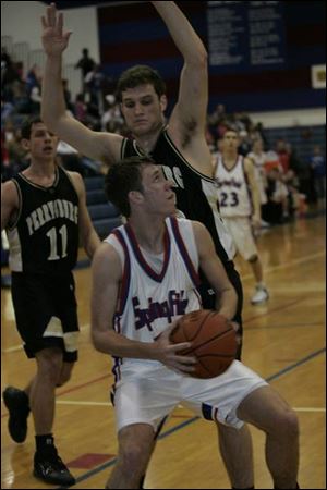 The Blue Devils' Cory Ubank goes up for a shot as Perrysburg's Glen Empie defends last night at Springfield.