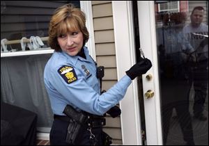 Officer Barbara Jackson simulates a break-in at a home in Point Place as Toledo Police begin a new, monthly program designed to educate residents on what to do if they are the victims of a crime.