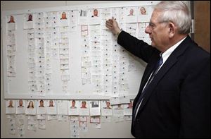 Sgt. Bob Baumgartner shows off a board that lists information and photos of suspects in an apparent safecracking ring.