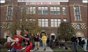 Cory Brown, left, and Allen Tigner, both 13, play with a basketball as classes let out for the day at Port Clinton Middle School.
