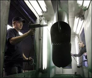 Matthew Peterman, left, and Sammy Harvey paint mailboxes at GDM in Huron. 