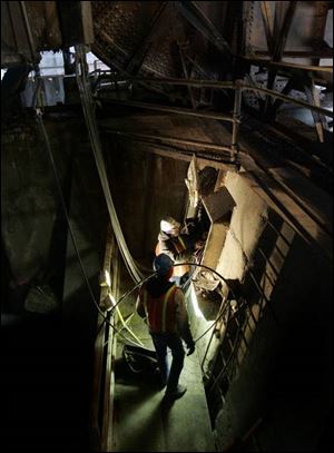 Electricians Kendra Allen and Ken Rettis (back to camera) rewire the controls under the eastside draw so the span can be operated from the new southeast tower.