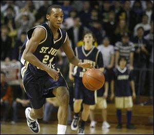 Jonathan Dunn charges up the floor for St. John s. Dunn scored 21 points to lead the Titans in scoring against Scott.
