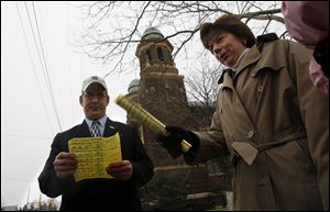 Steve Steel, left, a member of the Toledo Board of Education, reads statistics on Eagle Academy during the charter's open house. At right, teacher Robyn Hage talks to other teachers. 