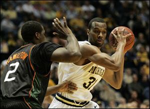 Michigan forward Chris Hunter goes to work against Miami forward Gary Hamilton during the first half of a 
National Invitation Tournament game in Ann Arbor. The Wolverines advanced to the semifinals in New York.