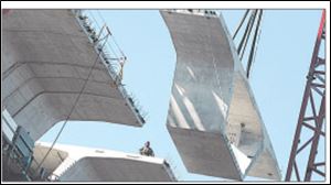 Workers install a section of the Veterans Glass City Skyway in Toledo in November. The project has suffered many setbacks.