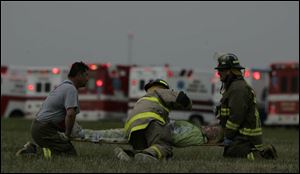 Firefi ghters hone their skills during a disaster drill by practicing treating the injured.
