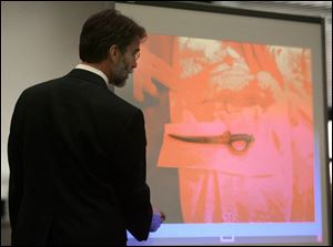 Assistant prosecutor Dean Mandros shows the suspected murder weapon displayed on the altar cloth and the matching blood stain to the jury in Lucas County Common Pleas Court.

