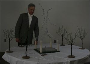 Evan Lewis of Chicago shows his proposed sculpture: four pillars shaped to mimic the piers
of the I-280 span, topped by stainless steel elements that would respond to the wind.
