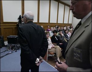Father Robinson is escorted from the courtroom by security officer Bob Dietrich after sentencing by Judge Thomas Osowik.
