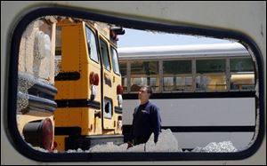 Scott Liber, one of the owners of Goody's on Lewis Avenue, inspects the damage to vehicles in his lot. The windows, headlights, and gauges of 80 to 90 buses, trucks, and other vehicles were damaged in a vandalism spree that resulted in an estimated $100,000 damage. The family business buys and sells used vehicles and recycles them for parts. 