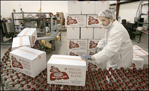 Jim VanderBussche takes completed cartons off the line.
