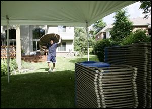 Jason Kurtz, of Meredith Party Rentals, hauls a table to join the chairs under a tent in Sylvania. 