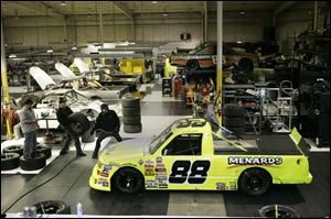 Crew members prepare to be timed during pit stop practice inside the ThorSport warehouse in Sandusky. Crews practice two pit stops per day at the facility. 