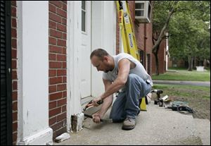 Sean Greenwood pries away part of a damaged door frame. 