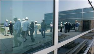 Visitors are reflected in the exterior green-colored glass, chosen to blend with the surroundings.
