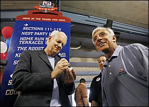 Mike Farrell, left, who played Capt. B.J. Hunnicut on 'M*A*S*H,' autographs a ball while Jamie Farr greets guests during the All-Star Bash at Fifth Third Field.