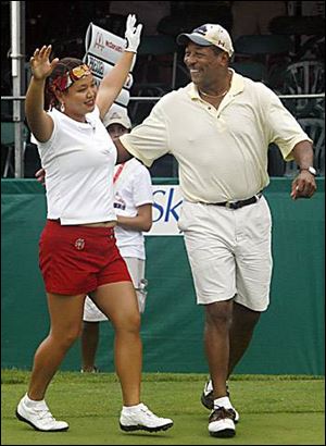 Former Rockets' QB Chuck Ealey celebrates winning the United Healthcare Celebrity/Pro Challenge with Christina Kim.