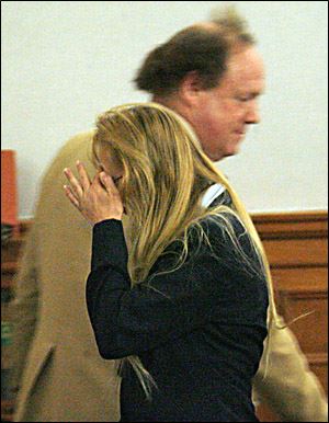 Dawn M. Fisher leaves Lucas County Common Pleas Court after her arraignment.