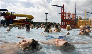 Dylan Coy, 12, left, of Maumee and Ethan Peters, 9, of Toledo float lazily in the pool at Maumee's Rolf Park. Yesterday's high was 92, and today's temperature is forecast to hover in the mid-90s.