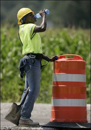 Ramelle Smith sips water
while working on Byrne Road
near Hill Avenue yesterday.
