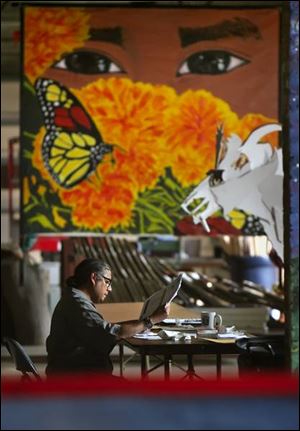 Known as an activist, Joe Balderas is executive director of the Sofia Quintero Arts and Cultural Center, handling paperwork amid artwork and other representations of Latino culture.