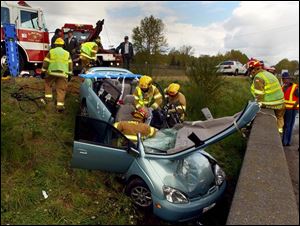 A rescue crew works to extricate a driver from a Toyota Prius after an accident near Olympia, Wash. With more hybrid cars on the road, rescuers are increasingly subject to a risk of electrical shock.