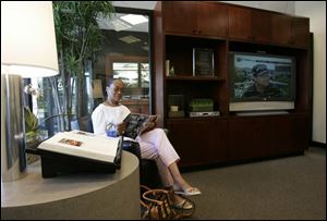 Vera Frazier reads in the lounge as she waits for her car to be serviced at the Sylvania Township Lexus dealership.