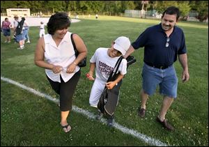 Martha Aguirre, her son Hector, Jr., 9, and husband Hector head home after a baseball game. Initially lonely after leaving a Chicago suburb, the Aguirres now say they feel at home here.