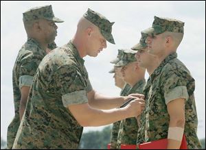 Marine Maj. Billy Brown bestows a commendation medal on Lance Cpl. Timothy Matanick. Others lined up to receive medals were Cpl. Tellis Hall, Lance Cpl. Dominic DeJohn, Sgt. Stephen Hooper, and Sgt. Scot Campbell of Sylvania.