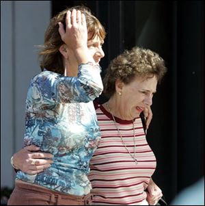 Patti Simon, left, and Becky Minsky leave the scene of a shooting at the Jewish Federation of Greater Seattle.