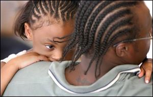 Appleseed Ridge Girl Scout Lazaria Baker, 6, clings to her father, John Baker. Baker could be incarcerated until 2020.