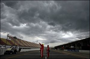 Track crew check out the ominous sky as a storm rolls in prior to the start of the race.