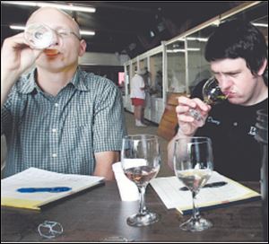 Nick Kubiak, left, and Evan Bates judge wine during a competition at the Wood County Fair, which opened yesterday.