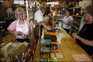 Diane Hudson, left, rings up a sale, as her husband, Bill, bags items for customers at their Cygnet grocery and carryout.
