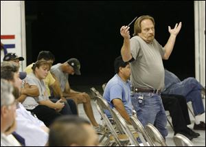 Mike Hall voices to officials his concerns about the plan to sell the village s electric system to Hancock-Wood Electric
Cooperative Inc. during a meeting last night at the fire hall. 