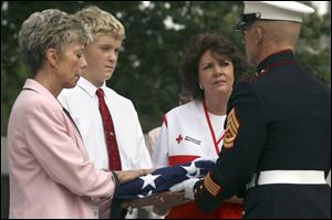 From left, Jane Moore of United Way, Joey Mravec of DeVeaux Junior High, and Deb Brough of the American Red Cross participate in the service with Marine Gunnery Sgt. Steven Kosinski.
