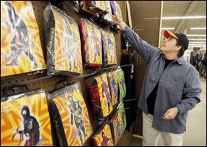Julie Kime selects from the display of ninja costumes at Halloween USA in the Southland Shopping Center in Toledo.
