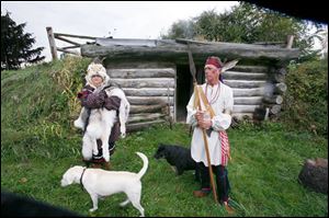 For the visitors, Linda Dix, left, and Martin Nagy strike a pose outside a cabin in Wood County.