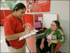 Lenesa Dunahoo, a supervisor at a Target on Monroe Street, asks job applicant Amanda
Bahlhorn, of Toledo, about her availability during the application process for holiday jobs.
