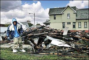 Tony Anderson removes some of the charred remains of a duplex on East Broadway.