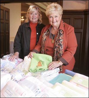Ann Meier, left, and Jeannie Rerucha with baby gifts to be donated through the Christ Child Society s Red Wagon Shower.
