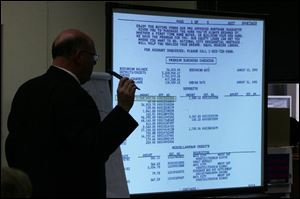 Defense attorney Bill Wilkinson reviews for the jury a printout of business transactions during Tom Noe s embezzlement trial yesterday in Lucas County Common Pleas Court.
