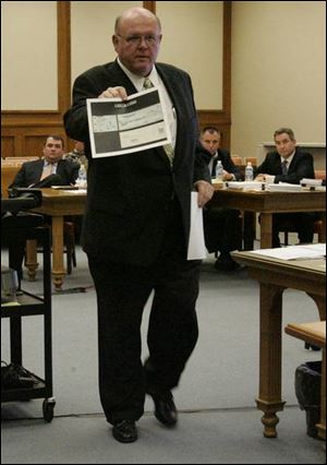 Defense attorney Bill Wilkinson
shows a witness evidence in
Lucas County Common Pleas
Court, where Tom Noe is on trial
on embezzlement charges.
