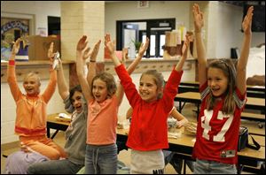 Rachel Lewandowski, Rosie Morningstar, Samantha Greeley, Kelsey Varwig, and Cortney Fornwale, all 9, lead a rousing cheer for the Ohio State side.