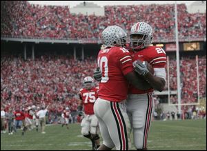 Ohio State quarterback Troy Smith, left, hugs freshman running back Chris Wells after Wells scored on a 52-yard touchdown run against Michigan.